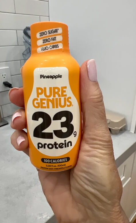 Customer holding a Pure Genius Pineapple protein shot