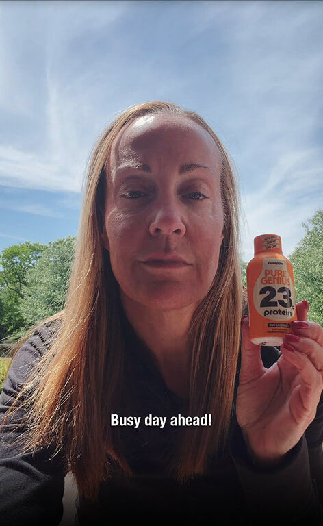 Customer holding a Pure Genius Pineapple protein shot outdoors, captioned &ldquo;Busy day ahead!&rdquo;