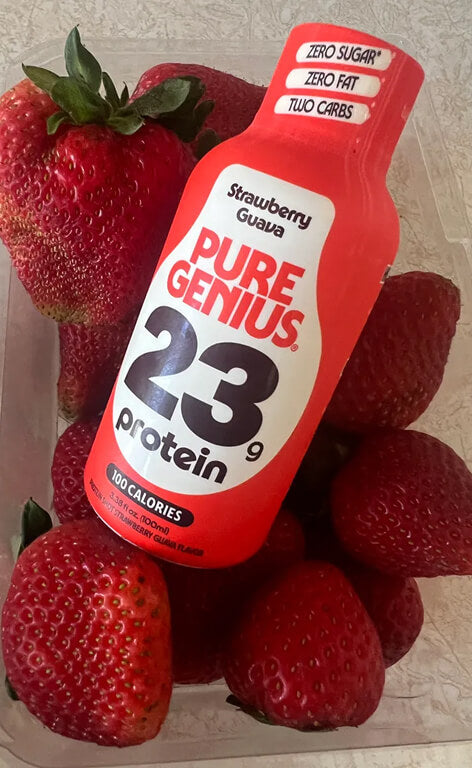 Pure Genius Strawberry Guava protein shot resting in a punnet of strawberries