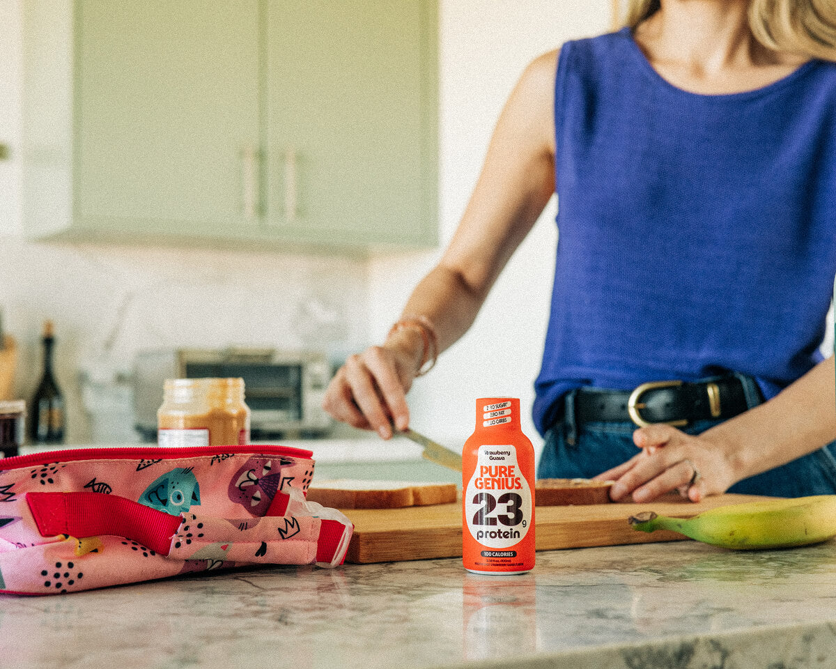Woman preparing food in her kitchen next to a Pure Genius protein shot