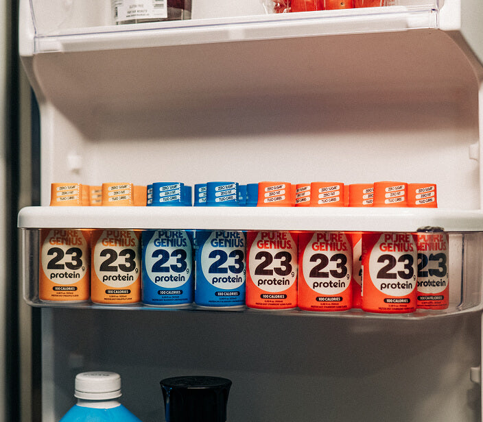 A fridge shelf stocked with a row of Pure Genius protein shots