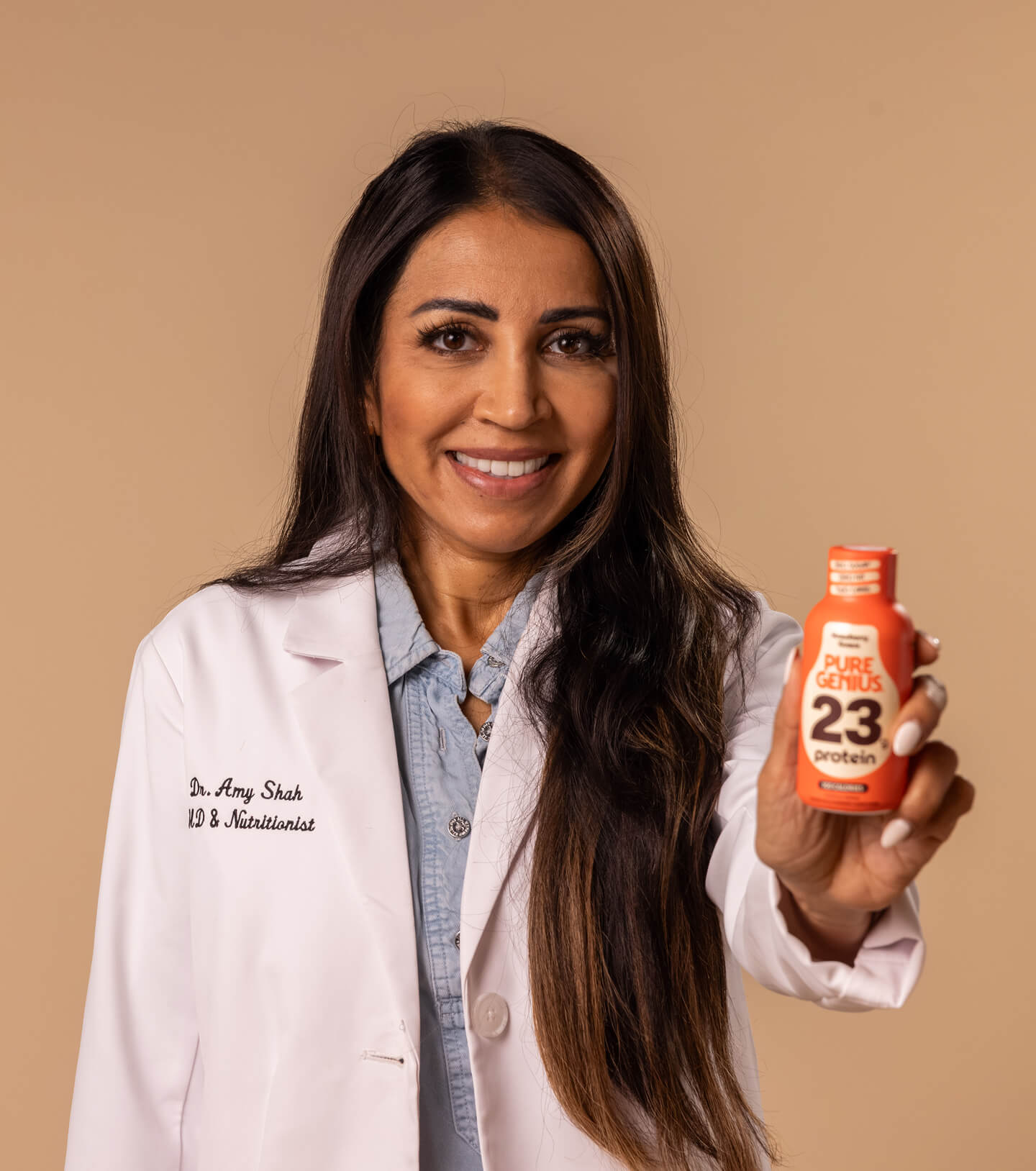 Dr. Amy Shah, MD & nutritionist, holding a Pure Genius 23g protein shot