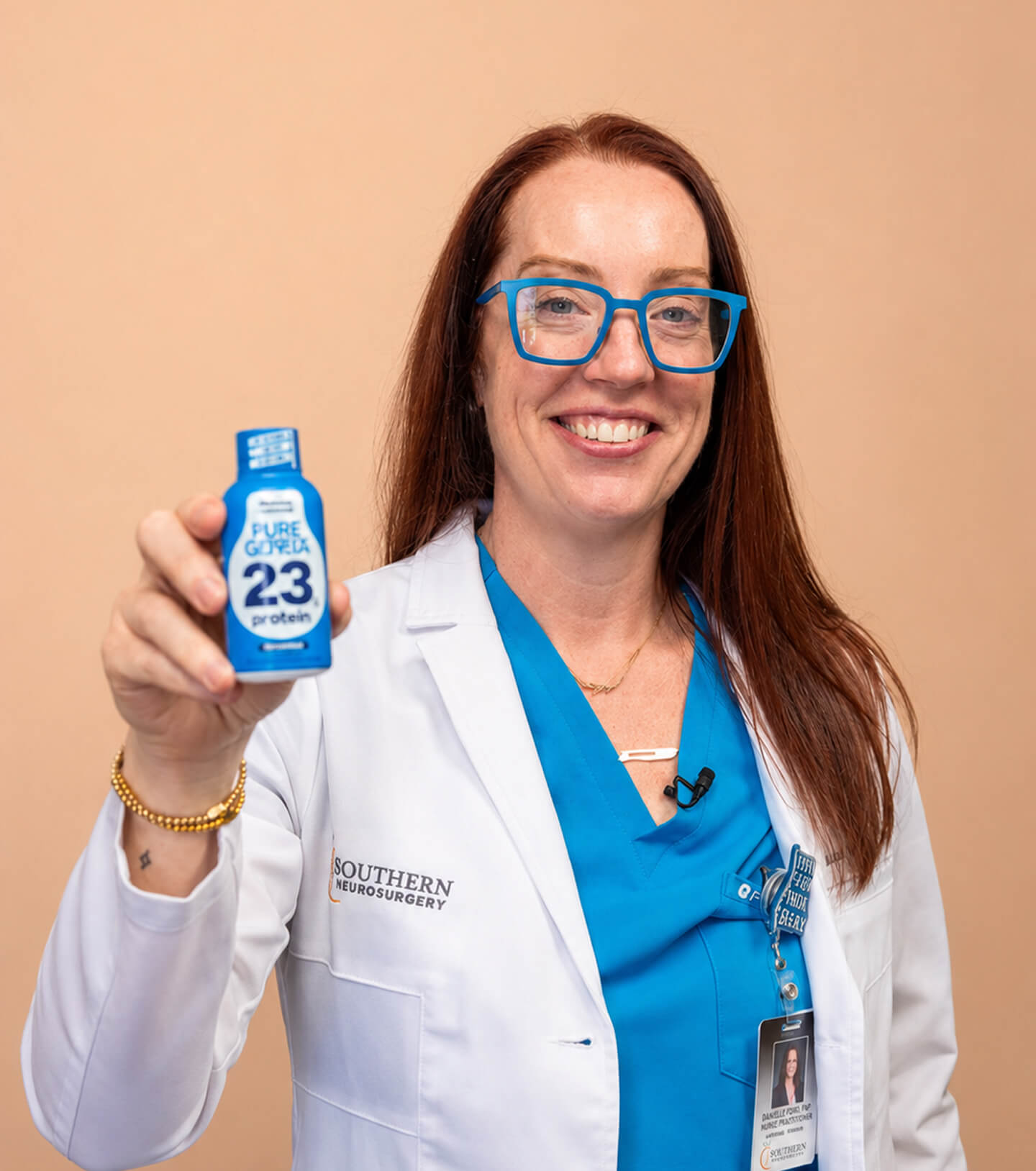 Dr. Amy Shah, MD & nutritionist, holding a Pure Genius 23g protein shot